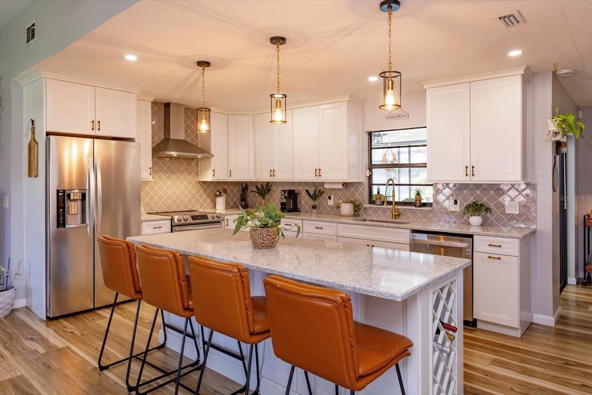 Beautifully renovated kitchen with shaker cabinets and quartz counters