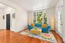 This beautifully appointed, sunlit room features gleaming pinewood floors, expansive windows, and glass doors extending the living space outdoors