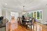 Dining area featuring wood-finish flooring, crown molding, an expansive bay window, and a decorative tiered chandelier