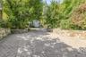 Paver driveway framed by natural stone retaining walls offering plenty of parking