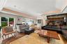 Expansive interior space featuring a multi-tiered tray ceiling with cove lighting, intricate parquet wood flooring, and a custom built-in wooden bar w