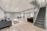 Finished space featuring wood-finish flooring, a drop ceiling with recessed lighting, vertical paneled wall treatments, and a carpeted staircase with 