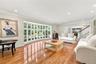 Spacious room featuring wood-finish flooring, recessed lighting, crown molding, and a large multi-pane bay window