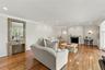 Hardwood flooring, crown molding, recessed lighting, and stone fireplace surround