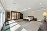Expansive room featuring built-in floor-to-ceiling wooden cabinetry, polished stone flooring, recessed ceiling lighting, and sliding glass doors