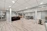 Finished lower level featuring wood-finish flooring, recessed lighting, drop ceiling, vertical paneling, and built-in shelving