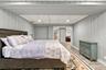Finished room featuring vertical paneled walls, recessed ceiling lighting, a drop-ceiling grid, and wood-finish flooring