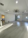Tray ceiling with recessed lighting, wood-finish flooring, and a multi-blade ceiling fan