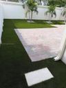 Backyard featuring synthetic turf, paver patio, perimeter wall, and mature palms