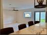 Stone-finish countertop, neutral tile flooring, recessed lighting, ceiling fan with light kit, and sliding glass door
