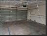 Multi-car garage featuring a sectional overhead door, automated door opener, and exposed interior wall conduit