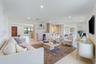 Open-concept interior featuring light-toned neutral flooring, recessed lighting, and a built-in wet bar with a glass-front beverage refrigerator and o