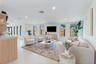 Open-concept interior featuring light-toned tile flooring, recessed ceiling lighting, vertical windows, and a built-in cabinetry unit