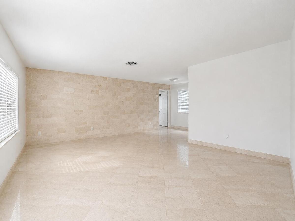 Recessed ceiling lighting, tiled flooring, tiled accent wall, and window with horizontal blinds