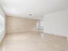 Recessed ceiling lighting, tiled flooring, tiled accent wall, and window with horizontal blinds