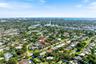 Aerial perspective showcasing a residential property with a swimming pool, mature perimeter landscaping, and proximity to the coastline