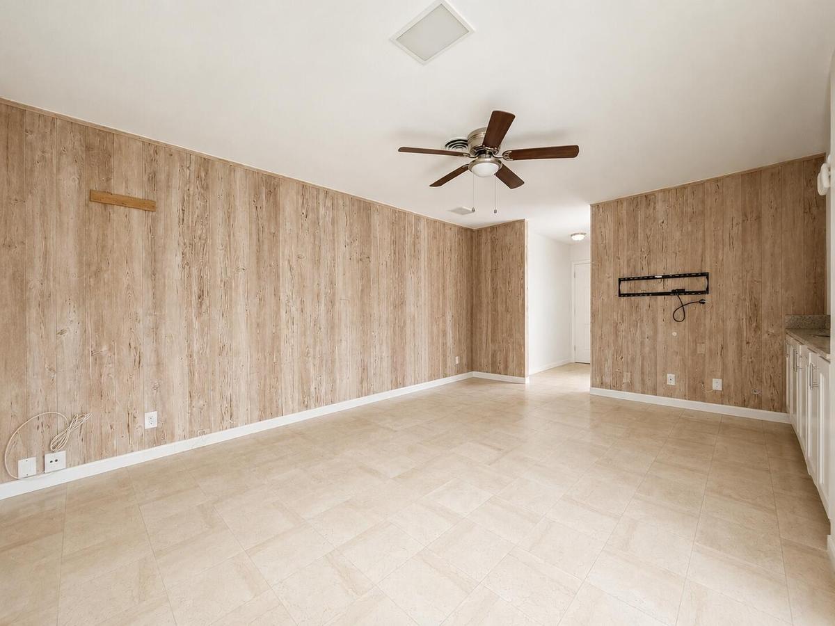 Wood-finish wall paneling, tiled flooring, and a ceiling fan