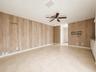 Wood-finish wall paneling, tiled flooring, and a ceiling fan