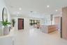 Open-concept space featuring large-format tile flooring, recessed ceiling lighting, a waterfall-edge kitchen island, natural wood-finish cabinetry, an