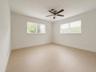 Recessed ceiling fan, two windows with blinds, wood-finish flooring, and white walls