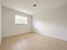 Neutral wall finishes with wood-finish flooring and a single window with blinds