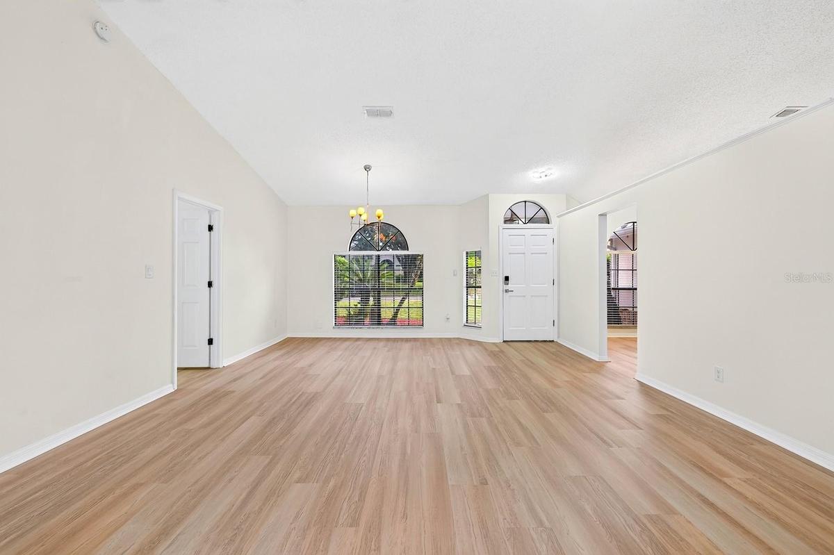 The formal Dining Room features an ELEGANT ARCHED LUNETTE WINDOW and flows into the Living Room.