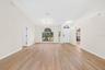 The formal Dining Room features an ELEGANT ARCHED LUNETTE WINDOW and flows into the Living Room.