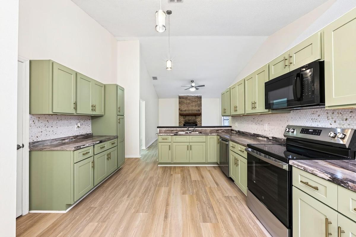 The beautifully REFRESHED KITCHEN offers an abundance of NEW CABINETRY and counter space, a convenient breakfast bar and NEW STAINLESS STEEL APPLIANCE