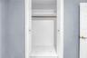 Third bedroom featuring a spacious closet with hidden floor-level storage.
