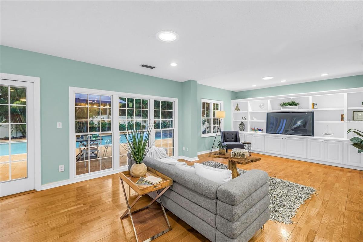 Spacious, casual living area adjacent to the kitchen, featuring direct views of the heated pool—an ideal setting for entertaining and watching the gam