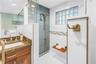 Exquisite spa-inspired walk-in shower featuring a built-in bench and a handheld shower wand.