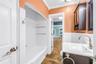 The Jack and Jill bathroom features a recently refinished shower, a modern updated vanity, and a convenient linen closet.