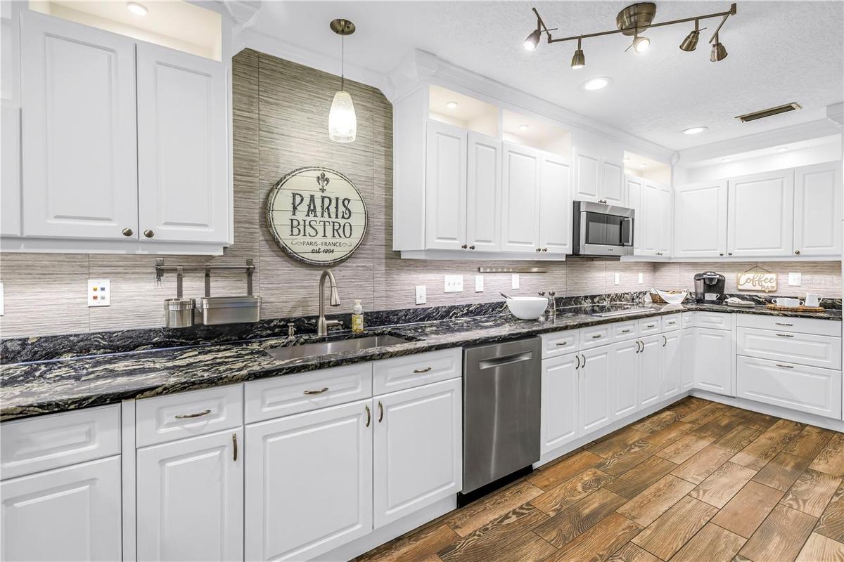 This spacious gourmet kitchen features high-end granite countertops, premium stainless steel appliances, and an elegantly designed backsplash.