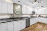 This spacious gourmet kitchen features high-end granite countertops, premium stainless steel appliances, and an elegantly designed backsplash.
