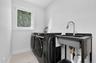 Utility area featuring large-format tile flooring, a casement window, and a free-standing basin with a pull-down sprayer faucet