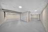 Open-concept lower level featuring spray foam insulation, painted concrete flooring, flush-mount lighting, and exposed steel structural supports