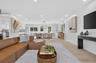 Open-concept interior featuring light wood-finish flooring, recessed lighting, and a geometric chandelier