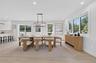 Dining area featuring wood-finish flooring, recessed lighting, a modern geometric chandelier, large windows, and a sliding glass door