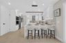 Kitchen featuring white cabinetry, quartz countertops, a mosaic tile backsplash, stainless steel appliances, and wood-finish flooring