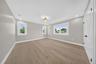 Room featuring wood-finish flooring, neutral wall paint, multi-pane windows, recessed lighting, and a drum-style light fixture
