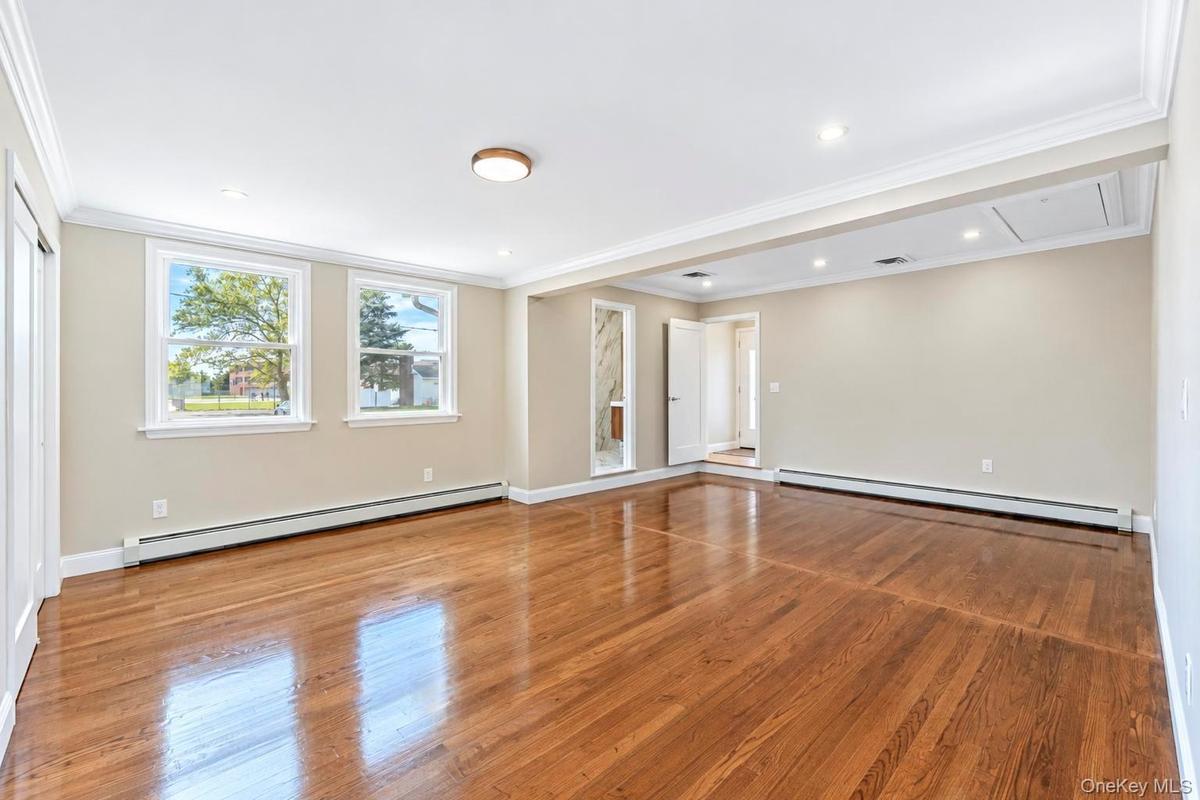 Interior space featuring wood-finish flooring, crown molding, recessed lighting, and double-hung windows