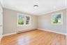 Neutral-toned interior featuring wood-finish flooring, crown molding, recessed lighting, and multi-pane windows