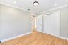Neutral-toned interior featuring wood-finish flooring, crown molding, recessed lighting, and a double-door reach-in closet