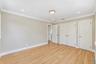 Room featuring light wood-finish flooring, neutral wall paint, recessed lighting, crown molding, and white solid-core interior doors with satin nickel