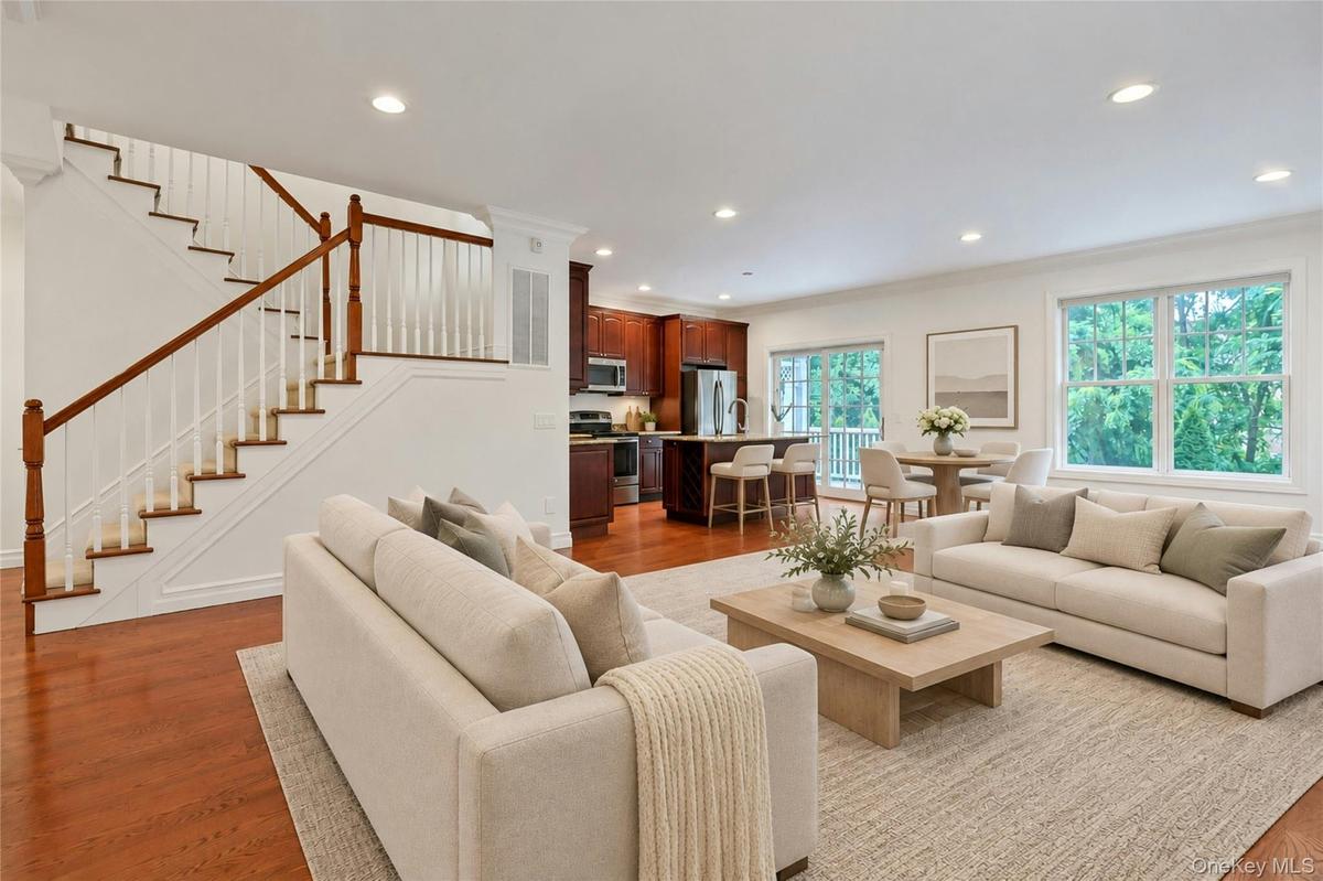 Sun-filled and spacious, the main level is designed for modern living with oversized windows, hardwood floors, a gas fireplace, and seamless flow betw