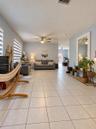 Neutral-toned ceramic tile flooring, ceiling fans, and dual-layered window shades