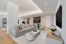 Recessed tray ceiling with integrated cove lighting, wood-finish flooring, and textured accent wall