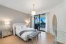 Light-filled room featuring wood-finish flooring, a globe pendant light fixture, and sliding glass doors opening to a covered balcony
