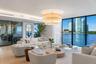 Open-concept living space featuring floor-to-ceiling windows, wide-plank wood-finish flooring, multi-tiered drum chandelier, and integrated cove light