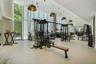 Fitness space featuring floor-to-ceiling windows, neutral tile flooring, recessed ceiling lighting, and suspended pendant fixtures with metallic inter
